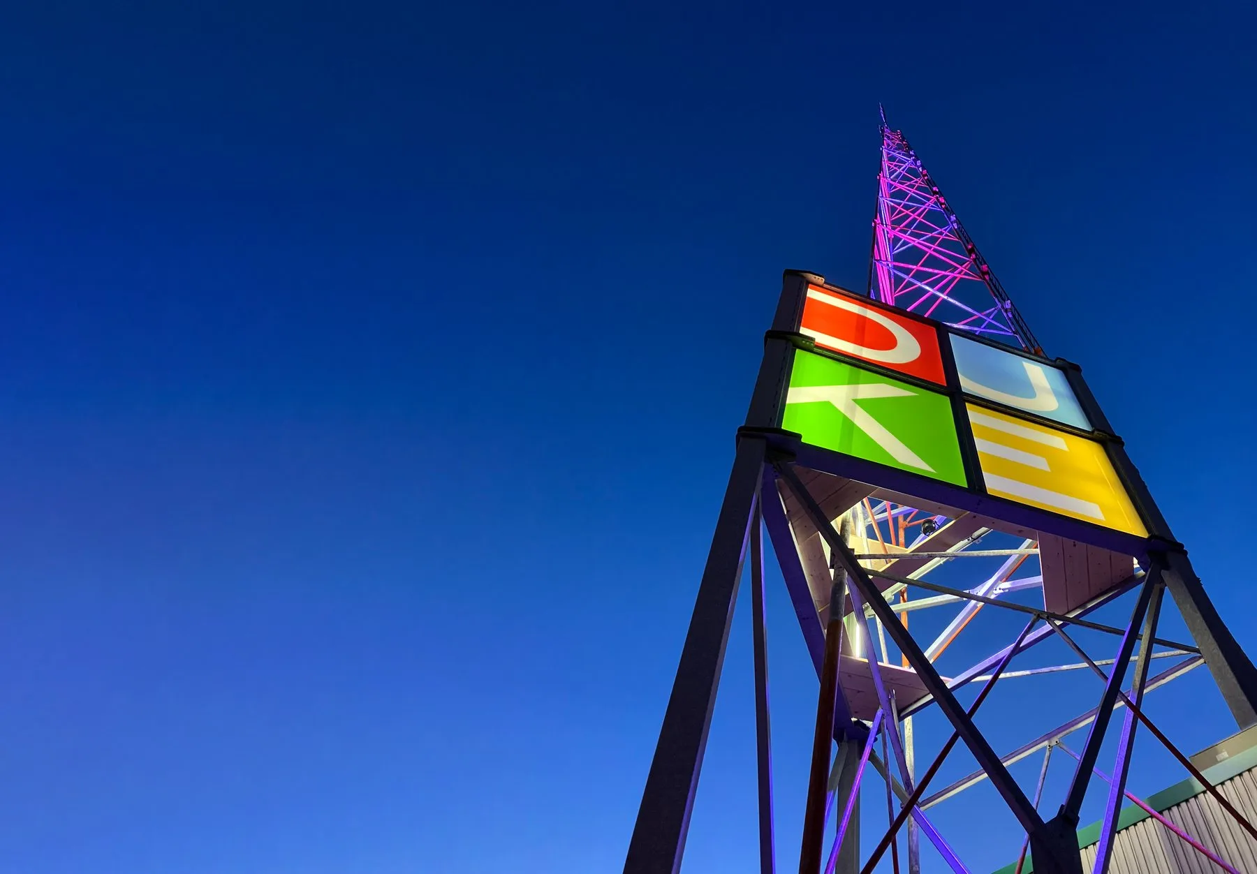 Illuminated Duke Heights signage tower against a blue sky