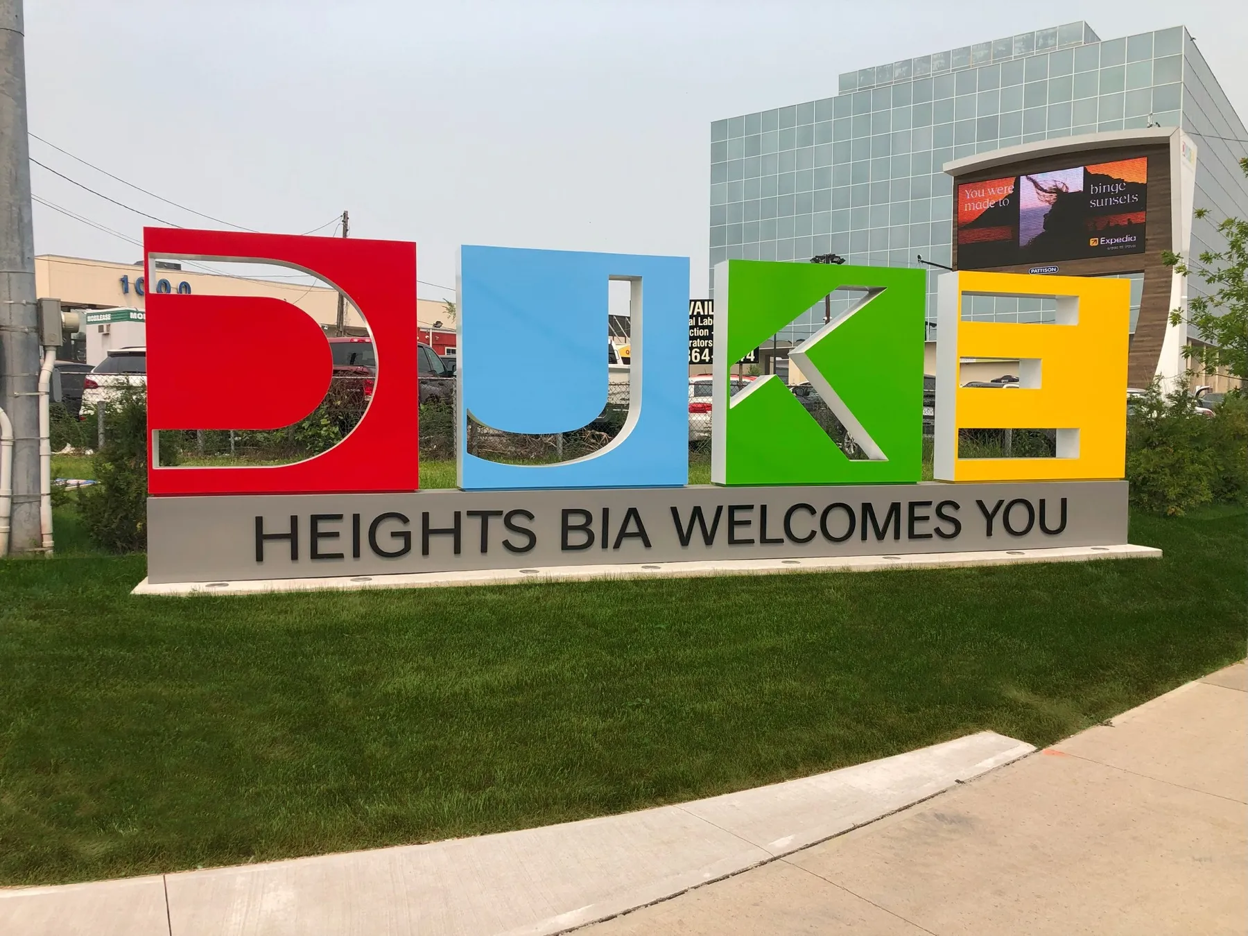 The revitalized corner at Dufferin and Keele, a large-format DUKE Heights BIA gateway sign marking the district boundary