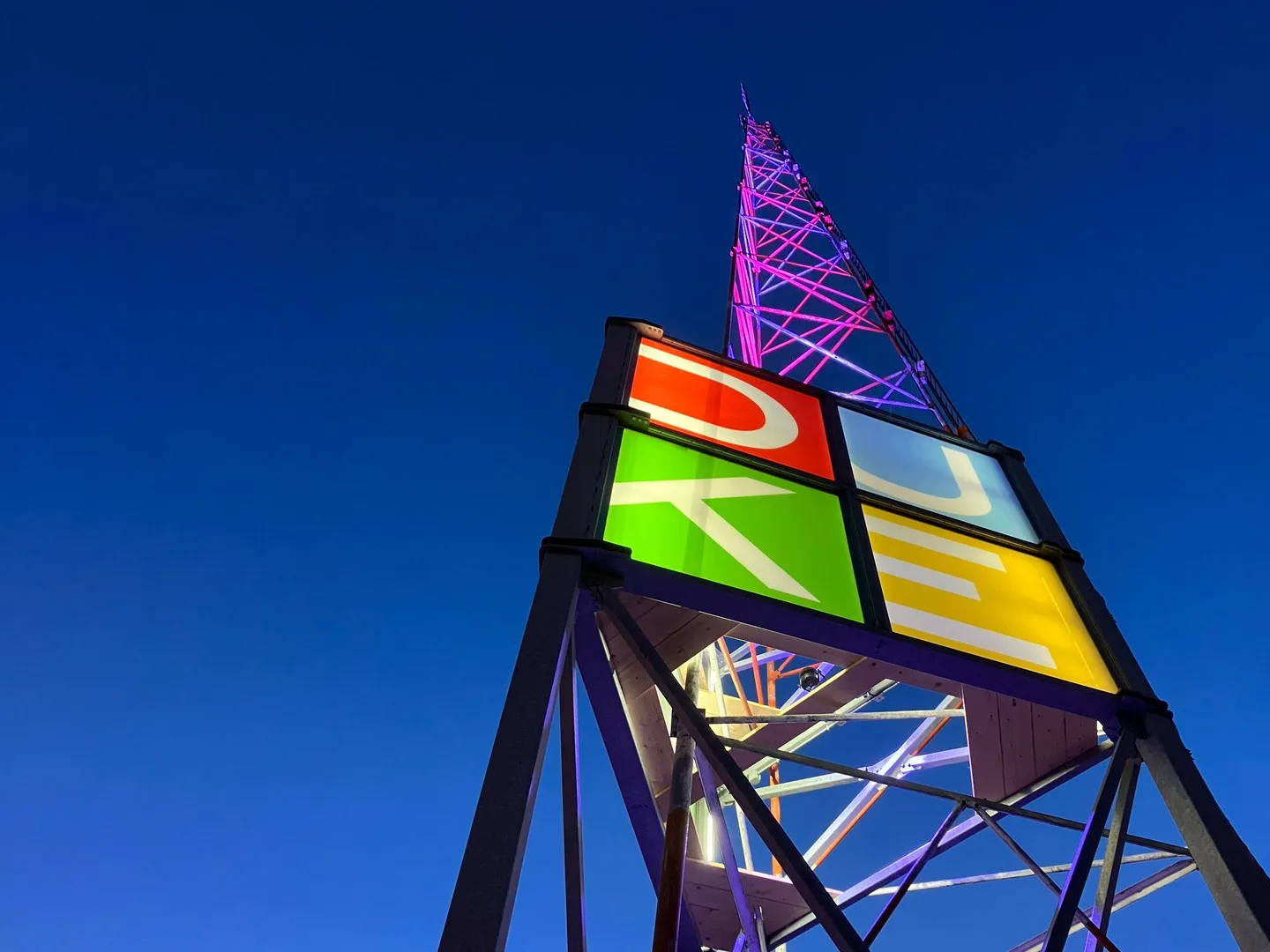 The Duke Heights BIA radio tower illuminated at night, its sign and mast lit against the sky